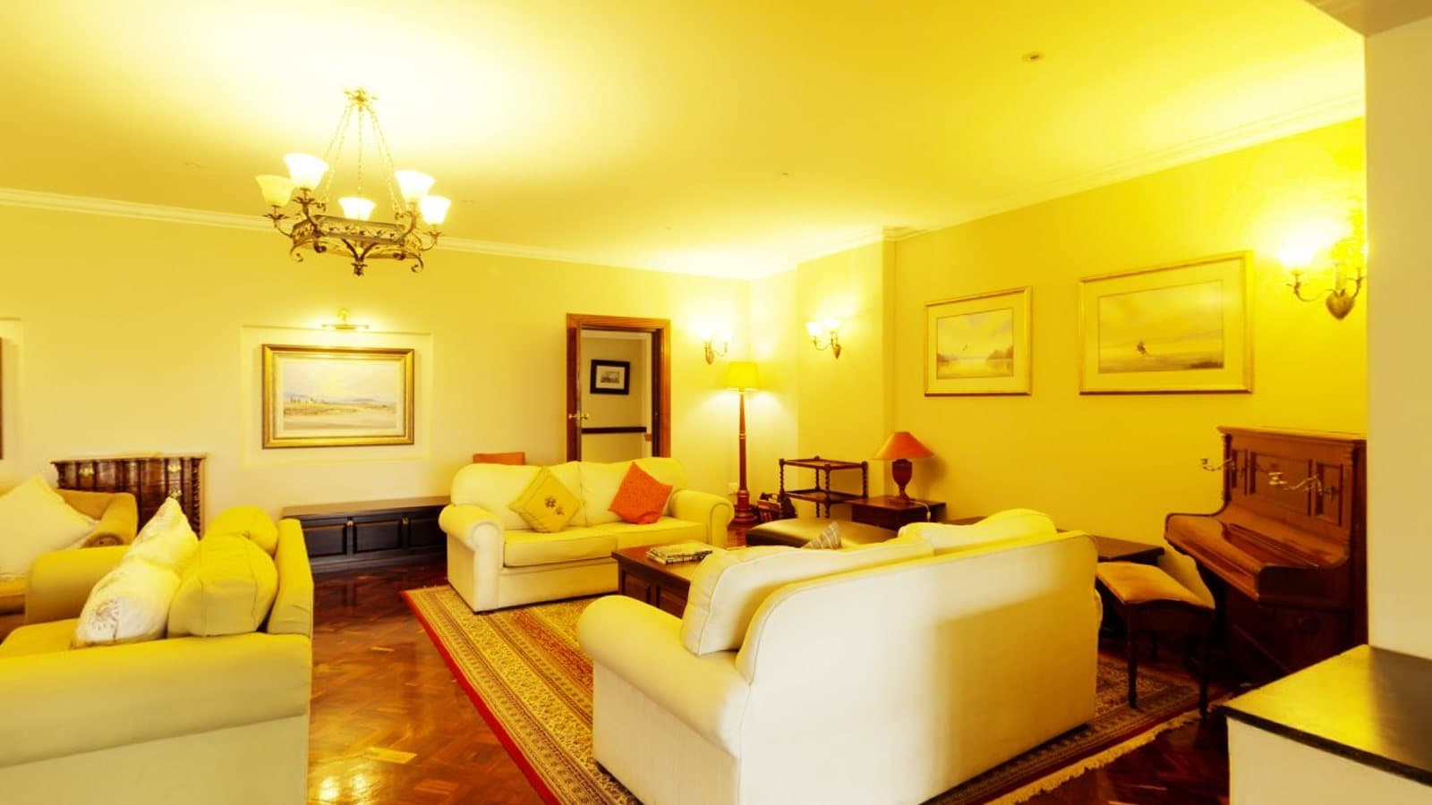 A furnished living room with sofas and a chandelier