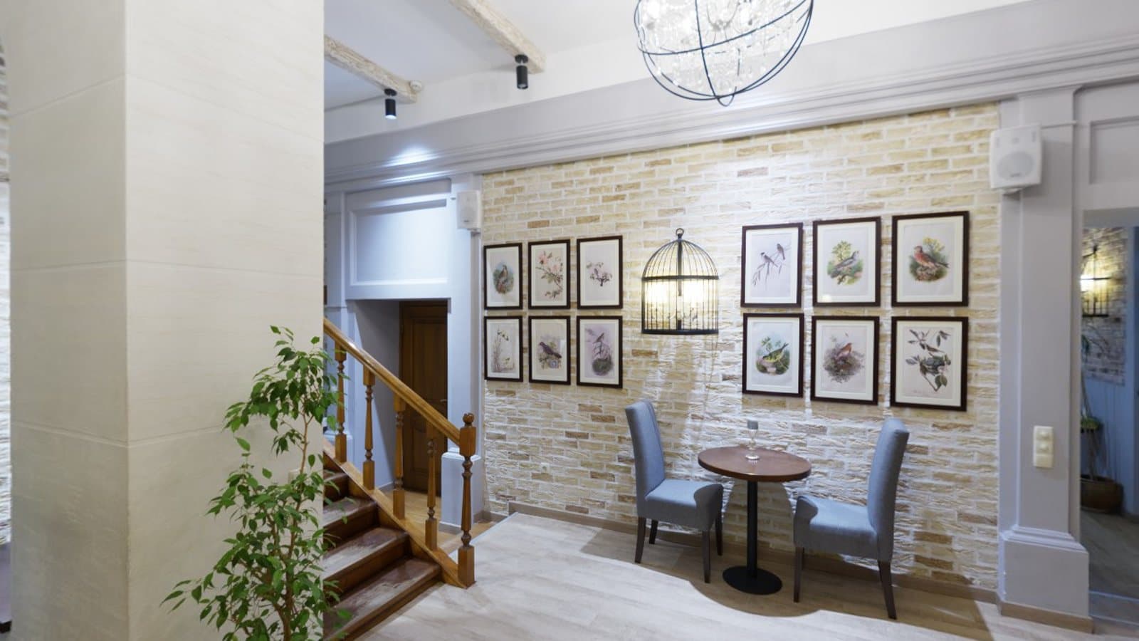 A cosy café interior with sofas, a staircase and framed pictures
