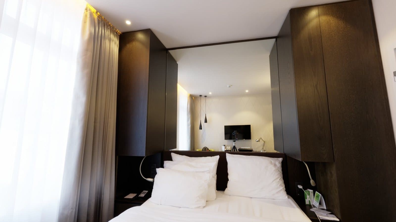 A hotel bedroom with a large bed, curtains and a desk
