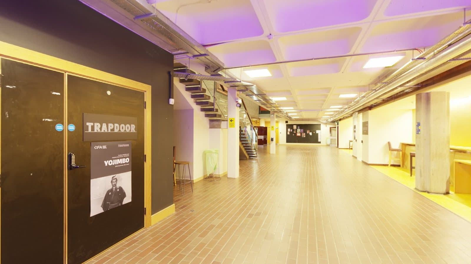 A bright, modern hallway with coloured lighting, suggesting a creative studio space